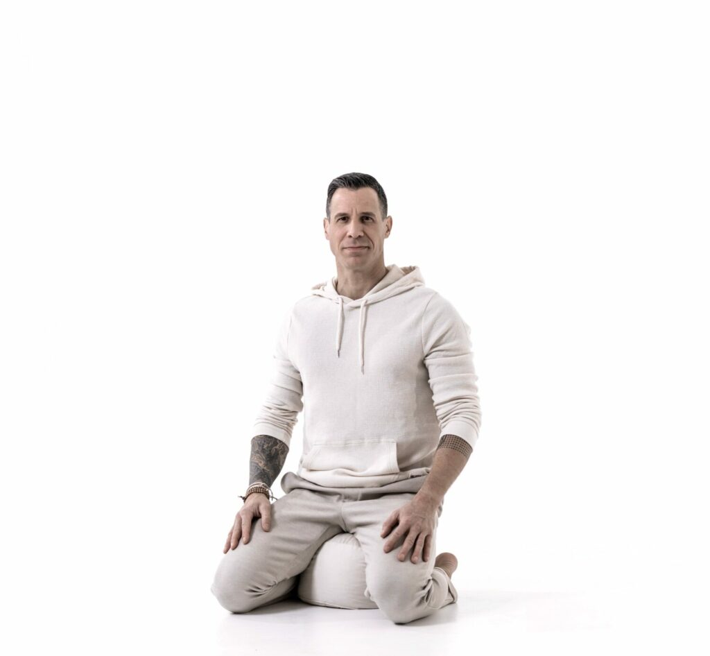 Ein Mann namens Michael Maizet sitzt auf einem Yoga-Kissen und wirkt entspannt und fokussiert.
